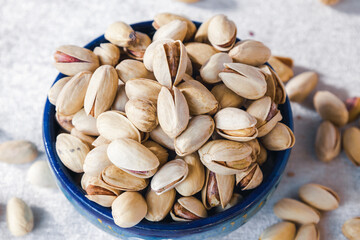 Close-up of pistachios in a blue bowl. Detailed view of nuts, healthy snack, food photography.
