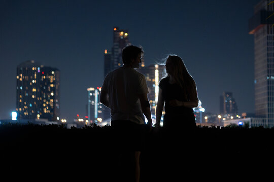 a couple in the city at night  - Powered by Adobe