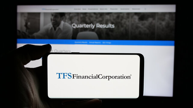 Stuttgart, Germany - 01-15-2025: Person holding cellphone with logo of American financial company TFS Financial Corporation on screen in front of webpage. Focus on phone display.