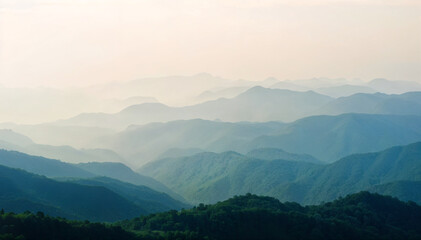Fototapeta premium Misty mountain range with layers of green peaks under soft morning light and hazy atmospheric view