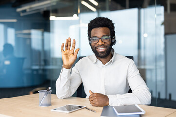 Web camera view, man with headset smiling and looking at camera, online business meeting...