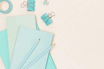 Mint colored school supplies on a beige background. Place for your design.