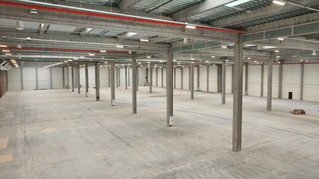 Inside of big industrial building. View from above of large, modern, logistics hub. Shot from drone of empty huge industrial area. Indoors. Aerial perspective. Delivery concept. Storehouse