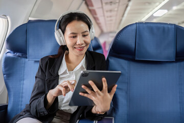Businesswoman Using Tablet on Airplane for Online Work During Flight, Embracing Modern Technology and Travel