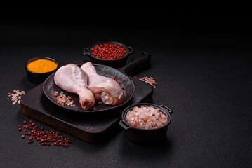 Raw chicken legs with salt, spices and herbs