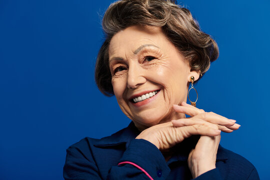 A stylish woman in her 60s beams with confidence while showcasing her timeless beauty.