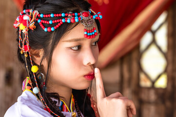Portrait young pretty Tibetan girl dresses in traditional tibet costumes with colorful headpieces