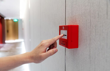 People hand pressing fire alarm