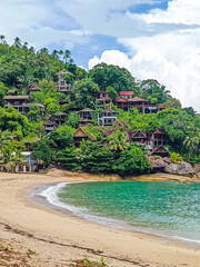 Secluded Tropical Paradise: A serene beach cove nestled amidst lush greenery and towering cliffs, ...