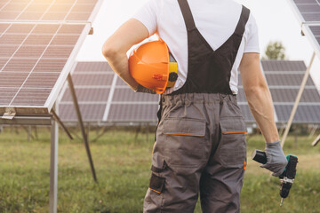 Technician Inspecting Solar Panels in a Sunny Field