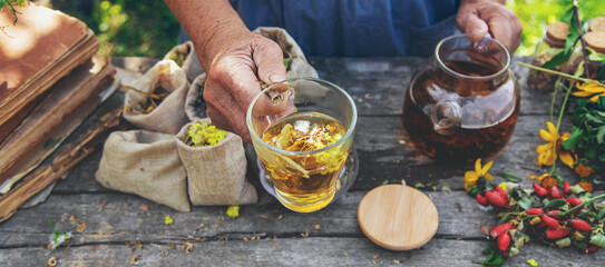 Medicinal herbs and tea old woman. Selective focus.