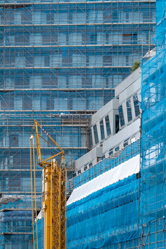A construction site showcasing scaffolding and heavy machinery, emphasizing the process of urban development and the transformation of architectural spaces.