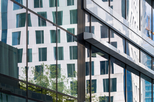 This image captures the mesmerizing reflection of modern architecture, highlighting glass surfaces and unique shapes that enhance the artistic feel of urban living.