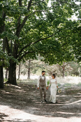 guy and a girl newlyweds are walking in the forest