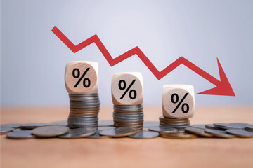Percentage sign on wooden cubes with Stack of coin bar chart and red graph trending downwards on white background. Economy recession crisis, inflation, stagflation, business and financial loss concept