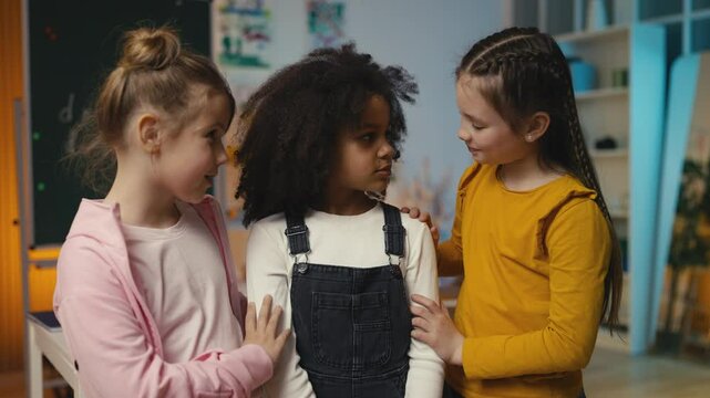 Two sympathetic girls comfort and hug their sad friend, friendship and support