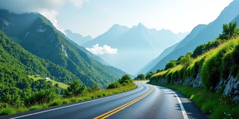 Fototapeta premium A scenic winding road journey through a vibrant mountainous landscape with lush green hillsides and a tranquil blue sky