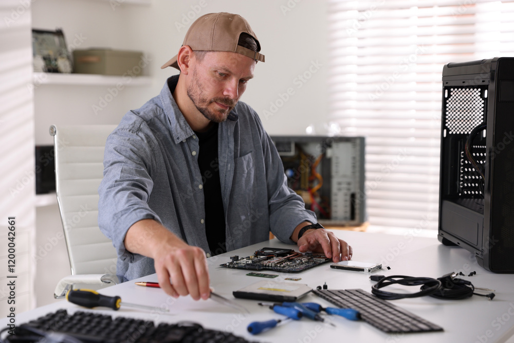 Aufkleber man installing computer chip onto motherboard at white table