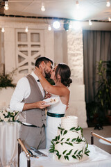 newlyweds happily cut and taste the wedding cake