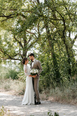 guy and a girl newlyweds are walking in the forest