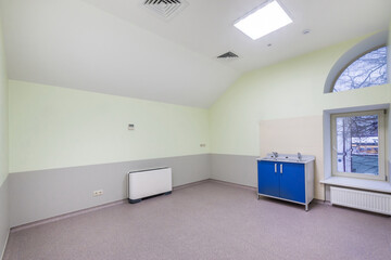An empty medical office in the attic with a large window. Unfurnished.