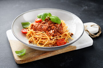 Traditional italian food - spaghetti bolognese with fresh basil leaves and parmesan cheese	