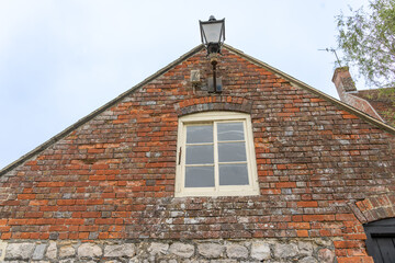 Old weathered red brick end wall and gable