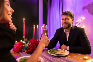 Happy lovers on romantic date drinking champagne, celebrating Valentine's day evening in calm atmosphere