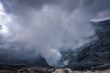 A breathtaking and dramatic view of an erupting Bromo volcano that is powerfully emitting thick clouds of ash and smoke, showcasing the incredible forces of nature at play, East Java, Indonesia