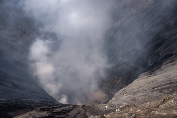 Breathtaking view of Bromo Volcano crater, a volcanic eruption, showcasing smoke and ash in a...