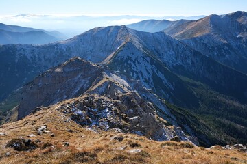 Panorama of Czerwone Wierchy range from around Kasprowy Wierch Peak, Tatras Mountains, Poland. During trekking red trail on sunny autumn day. Little silhouettes of people on trail. © Iwona
