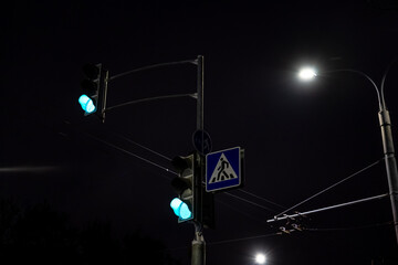 Green traffic light for cars. Traffic lights at night in the city
