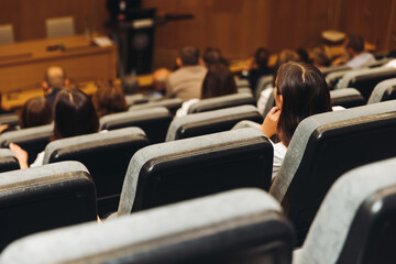 College students class with the professor in the auditorium, audience at the conference hall listens to lecturer, lecture seminar together listen to teacher, university classroom with faculty member