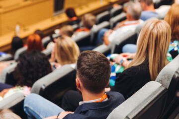 College students class with the professor in the auditorium, audience at the conference hall listens to lecturer, lecture seminar together listen to teacher, university classroom with faculty member