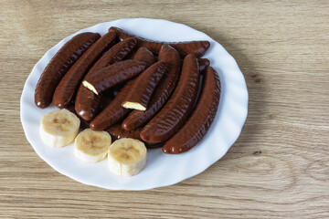 Banana flavored slices covered in chocolate on a plate