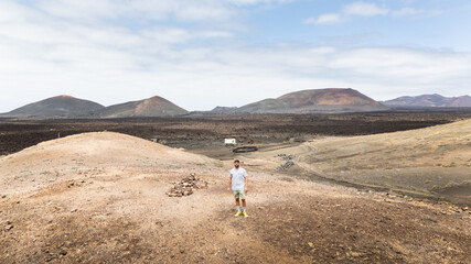 Drone view of a man exploring the volcanic landscapes of Lanzarote during a day