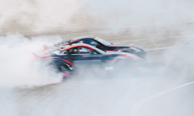 Blurred drift cars on a high-speed track in large quantities of smoke from burnt rubber wheels © Franchesko Mirroni