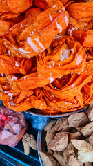 Close-up of two types of Indian sweets. Top portion features jalebi, bright orange spiral-shaped fried sweets with sugary glaze. Below, there are what appear to be soan papdi, flaky and crumbly sweets