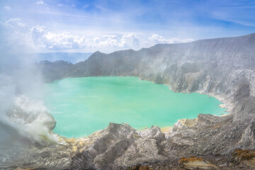 The breathtaking view of a stunning turquoise crater acid lake, burning sulfur deposit, nestled within the rugged volcanic terrain, showcases the beauty of nature, East Java, Ijen Volcano, Indonesia