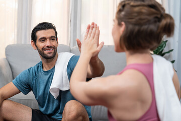 Obraz premium Athletic body and sporty young couple or workout buddy in sportswear high five after successful in home workout exercise at gaiety home exercise and healthy lifestyle concept.