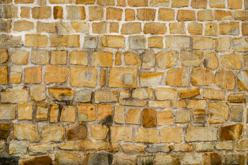 A wall built of rock blocks bonded with light concrete as a texture for graphics.