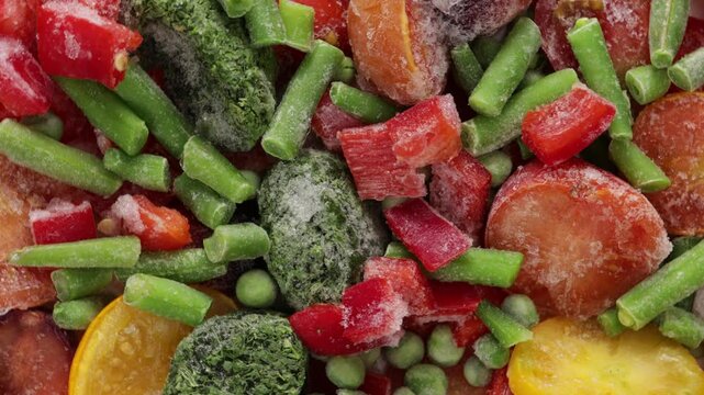 sliced red yellow tomatoes and paprika green vegetables frozen food background top view