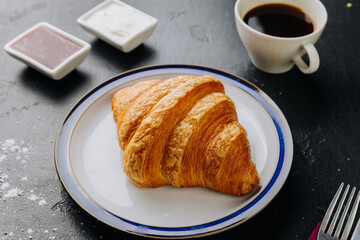Classic croissant with jam, cream, and coffee for a perfect breakfast treat