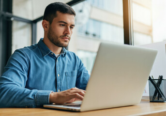 Focused Young Man Working on Laptop in Office