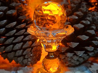 Crystal ball on a background of fire, pine cones nearby