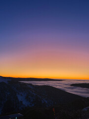 Sunset Over Mountain Range with Rolling Clouds