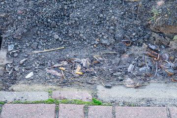 waste, small garbage, cigarette stubs in the drainage channel.