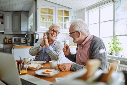 Happy senior couple having breakfast in the kitchen