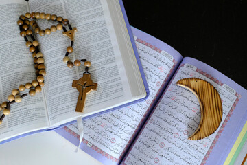 Religious symbols : Muslim Crescent  with Quran, and Christan Cross with Bible. Interreligious or...