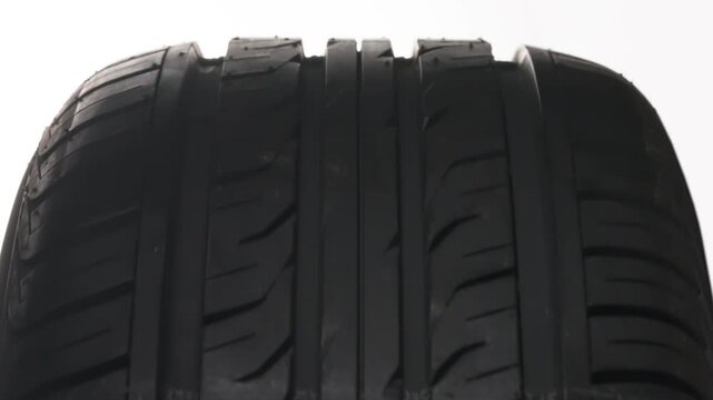 Symbol for Seasonal Tire Replacement. The concept of seasonal tire replacement. Close-up new car wheel slowly spinning. A cold weather warning sign appears on the tread side of the wheel
